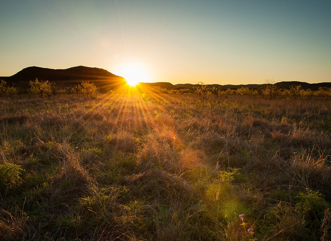 Andrews, TX - Scenic View of a Grassy Field with Hills in the Background at Sunset in a Park in Andrews Texas